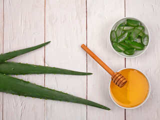 Aloe Vera and honey closeup on light wooden background. Top view. With copy space