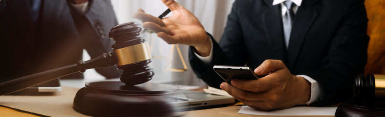 Business and lawyers discussing contract papers with brass scale on desk in office. Law, legal services, advice, justice and law concept picture with film grain effect