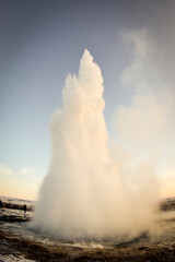 erupting geyser and people around it