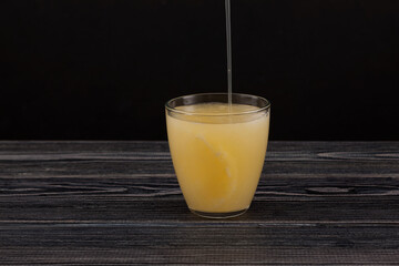Tepache - Popular mexican fermented pineapple drink.  Chilled drink poured into glass. Dark...