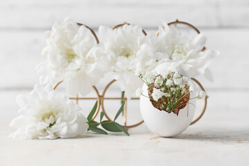 Creative composition with Easter egg and flowers on table