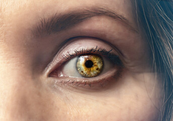 Woman's eye is bright, close-up. Dramatic contrast