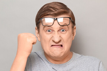 Portrait of angry annoyed man shaking fist in threatening gesture