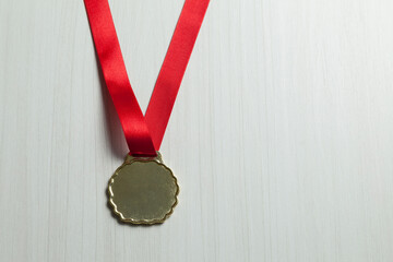 Gold medal on gray background and red bead. Olympics concept. Award concept.