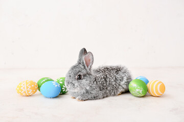 Cute rabbit and Easter eggs on light background