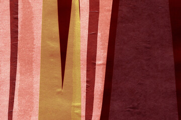 Fototapeta premium Red and brown torn paper collage close-up. Texture made from various paper and cardboard parts. Damaged old paper background. Vintage blank wallpaper. Material design backdrop.