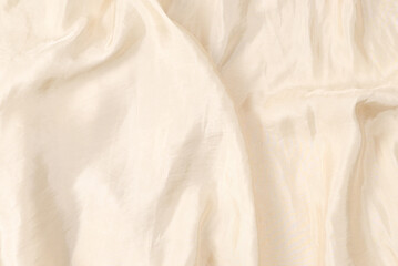 Soft smooth beige silk fabric background. Fabric texture.