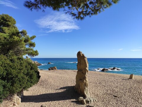 Vista de la playa de Platja d'Aro con su monolito de granito "Cavall Bernat". Playa de arena gruesa.