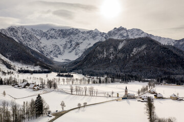 Aerial winter landscape with mountain village and forest covered in snow. Zgornje Jezersko, Slovenia.