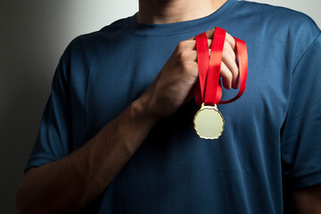 Athlete holding gold medal with his hands. Olympics concept. Medal concept.