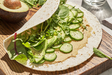 Vegetarian tortilla with hummus and green vegetables