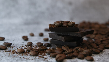 Close up of pieces of chocolate stacked over surrounded with coffee beans.