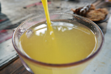 Close up of warm orange drink in a glass. Top view