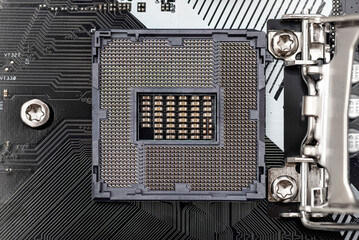 Top macro shot of empty modern LGA 1200 socket for CPU on black desktop motherboard.