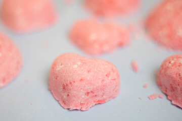 selective focus of a bath bomb from sea salt, citric acid, soda, dye and flavor on a blue background