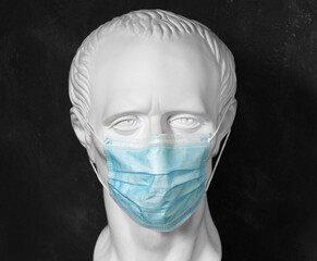 Plaster mannequin in a blue medical mask. Coronavirus protection concept.