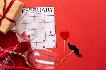Valentine's day February 14 mark on the calendar  page with red hand written heart highlight on Feb 14 , glasses, gift box over february calendar. Valentines day concept.