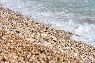 Beautiful blue lagoon with turquoise sea and wet pebble stones, with selective focus. Turquoise clean water background with natural stones. Fethie, Turkey 