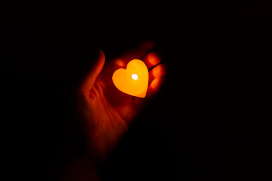 Candle Light Glowing In Woman's Hand. Praying, Faith, Religion Concept.Charity And Giving Back.  Faith, Charity, Sacrifice Concept. Save A Life.