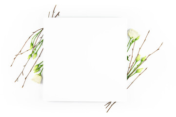 Spring composition. White flowers, paper blank white background. Flat lay, top view, copy space, mock up.