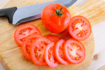 Pomodoro a fette su tagliere con coltello