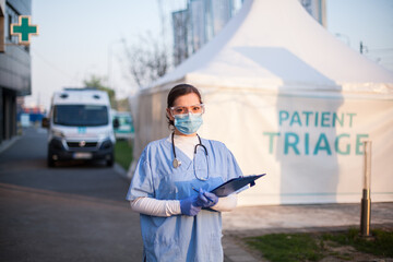 Portrait of serious female key front line worker in blue PPE uniform