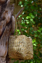 Human hand made dates tree box tool. palm leaf dry jar hanging on wood in garden, brown background culture thing Arabic style picture