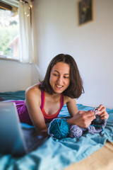 A woman is engaged in knitting, learning to knit online