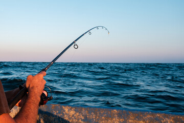 Fisherman fishing with rod from a boat in the sea