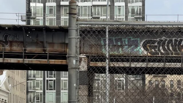 driving past graffifi elevated subway train track platform in Williamsburg Brooklyn New York City NYC 