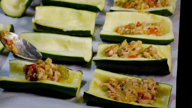 Preparation of zucchini stuffed with minced meat and fresh vegetables baked with gratin cheese, very healthy and wholesome for diets and weight loss.
