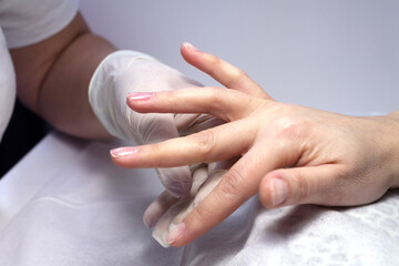 The process of manicure fitting natural nails filing nails coating with colored gel polish and glossy top.