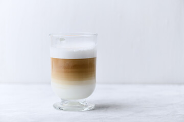 Coffee with milk on bright wooden background. Close up. Copy space.