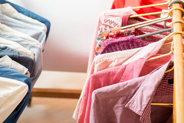 Clothes are hanging on hangers. Many things in the wardrobe on hangers