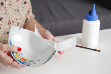 Woman repairing broken bowl using glue and brush. Serie of photos.
