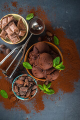 Dark Chocolate Ice cream. A lot of chocolate ice-cream with chocolate beans, powder and pieces, with icecream waffle cones and summer fresh berries on dark concrete background top view