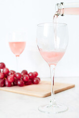rose wine is poured into a glass from a bottle