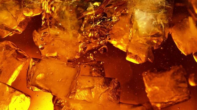 Super slow motion of rotating ice cubes in cola or alcoholic drink. Filmed on high speed cinema camera, 1000 fps.