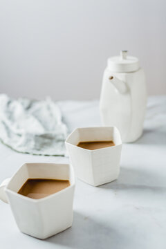 Artistic mugs and teapot with coffee