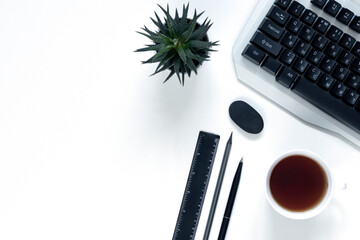 On a light background are a pen, computer, flower, cup of coffee. Place to insert text. Close up...
