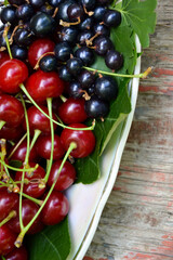 Berries organic harvest. Raspberry, black currant and cherry. Organic berries from village garden for jam, smoothie or desserts. Grunge wooden background.