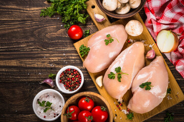 Chicken fillet with spices on dark wooden kitchen table. Top view with copy space.