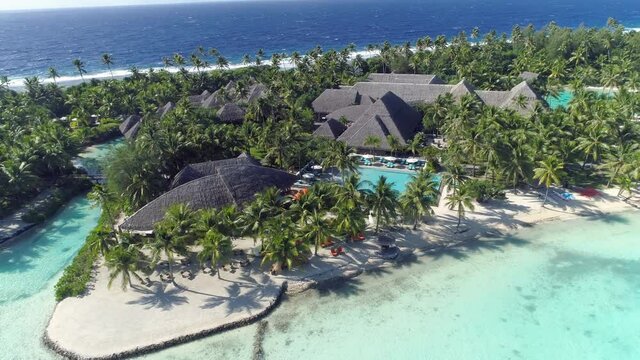 Aerial - Beautiful luxury resort in Bora Bora with turquoise water and lush palm trees. Picturesque holiday resort for perfect tropical vacation