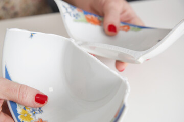 Woman repairing broken bowl using glue and brush. Serie of photos.
