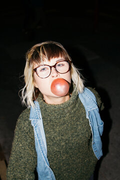 female teen tries to blow bubble with gum