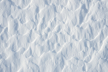 Fototapeta premium Fresh clean white snow background texture. Winter background with frozen snowflakes and snow mounds. Snow lumps. Seasonal landscape details. Cold weather.