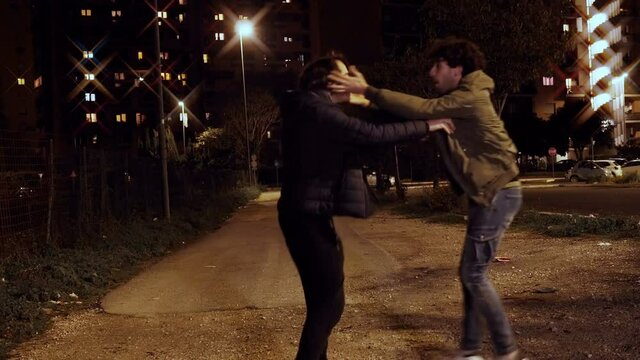 youth, joy - tipsy young men jump and hug each other in the street at night
