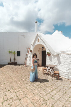 Woman In Front Of Traditional House In Alberobello, Italy