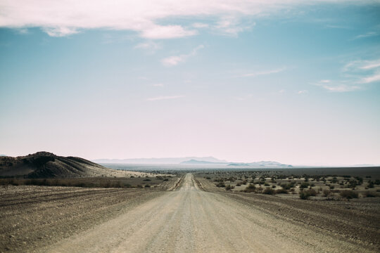 Long empty desert road heading into the horizon