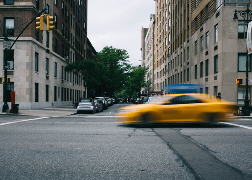 Taxi Zooming Through NYC Intersection